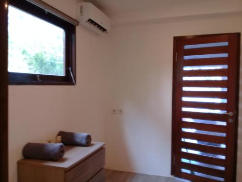 a room with a window and a wooden door at Castaway Surf Retreat in Sekongkang