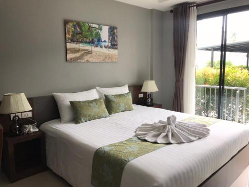 a bedroom with a large white bed with a window at Aonang Sea Valley Resort in Ao Nang Beach