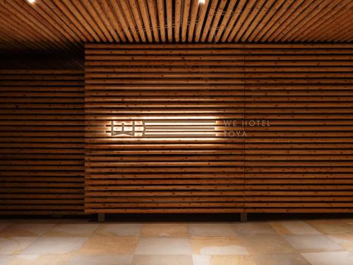 a room with a wall of wood paneling at WE Hotel Toya in Lake Toya