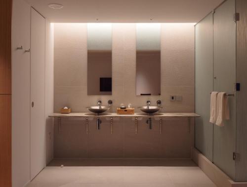 a bathroom with two sinks and two mirrors at WE Hotel Toya in Lake Toya