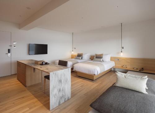 a hotel room with two beds and a television at WE Hotel Toya in Lake Toya