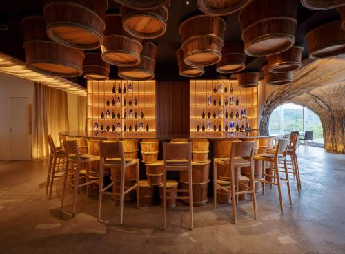 a bar with wooden stools and wine bottles at WE Hotel Toya in Lake Toya