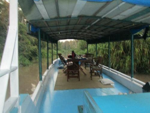 a patio with a table and chairs on a house at Orangutan Houseboat Park Tanjung Puting in Pangkalan Bun