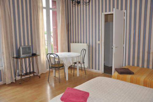 een kleine kamer met een tafel en stoelen en een bed bij Château De La Croix Bizet in Moulineaux