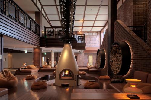 a lobby with a fireplace in the middle of a room at Lake Shikotsu Tsuruga Resort Spa Mizu no Uta in Chitose