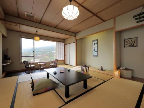 a living room with a table and a dining room at Kagamigaike Hekizantei in Nihommatsu