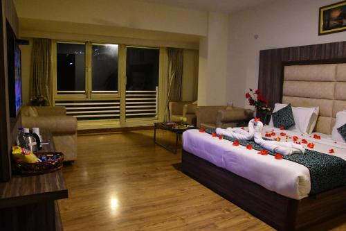 a bedroom with a bed and a living room at Rama Trident, Katra in Katra