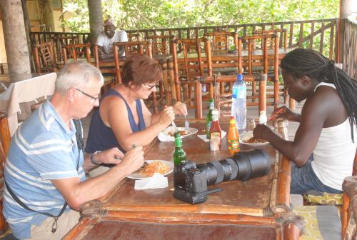 un groupe de personnes assises à une table avec une caméra dans l'établissement Bintang Bolong Lodge, à Bintang