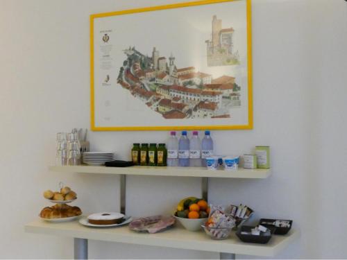 a shelf with bottles of water and a picture on the wall at Il Fiore di Monnalisa in Vinci