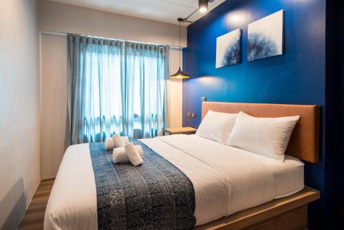 una camera da letto con un letto grande con una parete blu di Natee Hostel a Bangkok