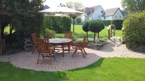 un patio con mesa, sillas y sombrilla en Haus Schütte, en Erwitte