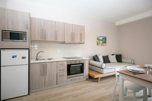 a kitchen and living room with a couch and a table at Electra Apartments in Sidari