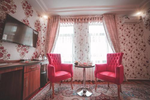 a room with two red chairs and a table at Asmald Palace Hotel in Kokand