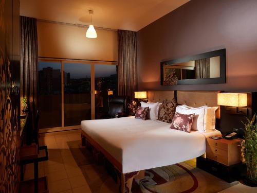 a bedroom with a large bed and a large window at ZiQoo Hotel Apartments Dubai in Dubai