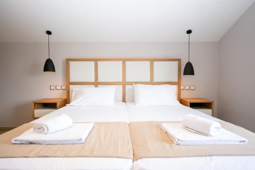 a bedroom with two beds with white towels on them at Electra Apartments in Sidari