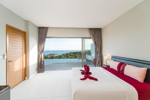 a bedroom with a large bed and a large window at Villa Marinella in Lamai