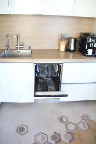 a kitchen with a dishwasher and a sink in a kitchen at Old Town Panorama Apartments in Klaipėda