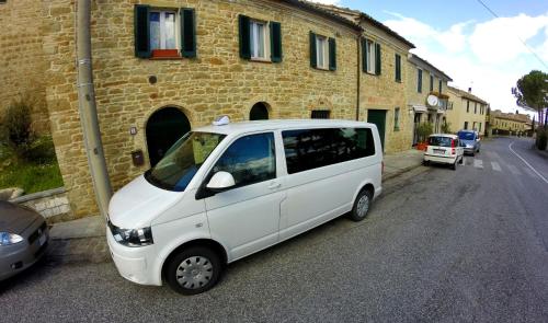 a small white van parked in front of a building at Il Gatto Sulla Finestra in Iesi