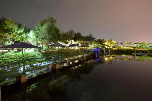 a body of water with umbrellas and a river at night at Lan People Villa in Qigu