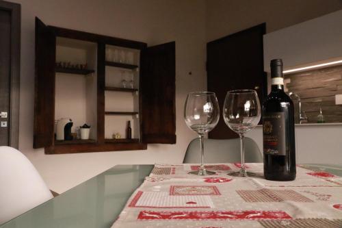 a bottle of wine sitting on a table with two glasses at L'armonia della natura in Aosta