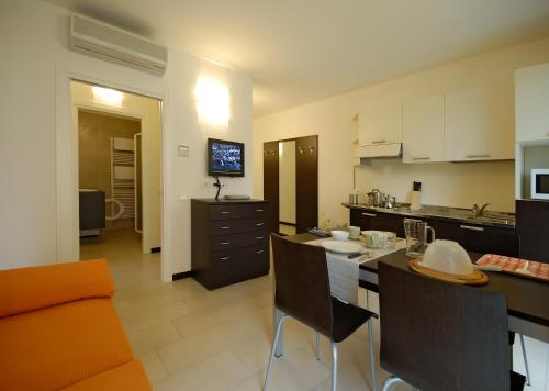 een keuken en een woonkamer met een tafel en stoelen bij Casa Piccola Torbole in Nago-Torbole