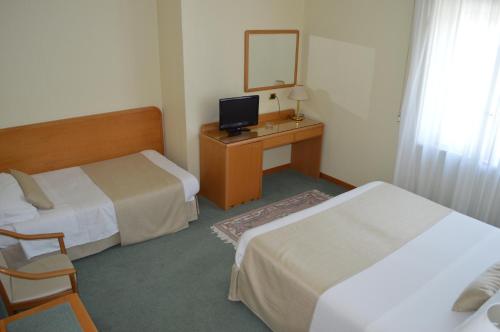 a hotel room with two beds and a desk with a mirror at Hotel Villa Ida in Ceprano