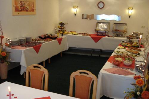a room with long tables and chairs with food at Hotel Bierstübl in Sangerhausen