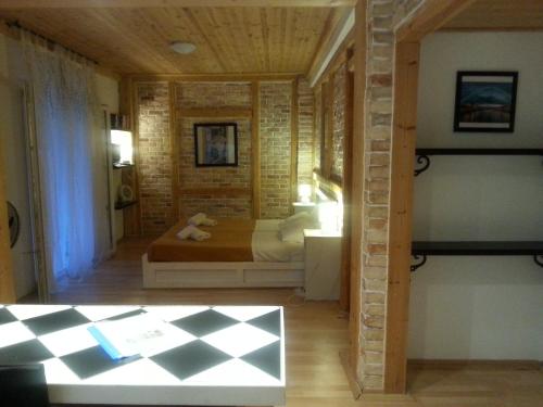 een slaapkamer met een bed en een bakstenen muur bij Villa Tasos in Acharavi