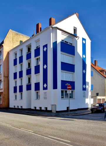 ブレーマーハーフェンにあるMonteurwohnungen Hanseatの青窓のある白い建物