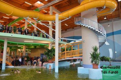 a water slide in a mall with people in the water at Royal Hotel in Cserkeszőlő