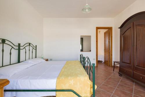 ウッジャーノ・ラ・キエーザにあるCasa Frulli by BarbarHouseのベッドルーム1室(ベッド1台付)、木製キャビネットが備わります。
