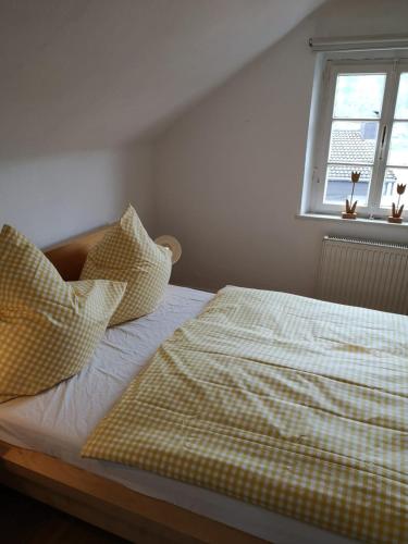 a bed with checkered sheets and pillows in a bedroom at Ferienhof Schmickerath in Simmerath