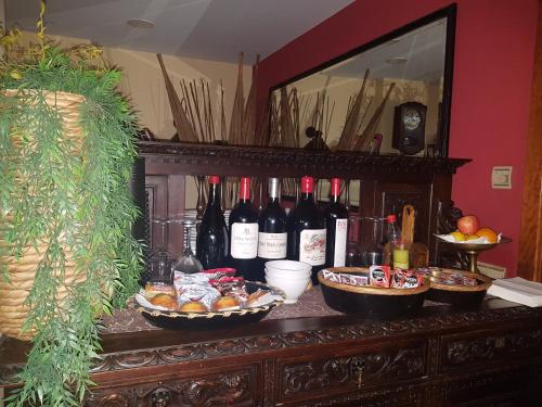 a table with bottles of wine and baskets of food at Hostal Los Canteros in Golmayo