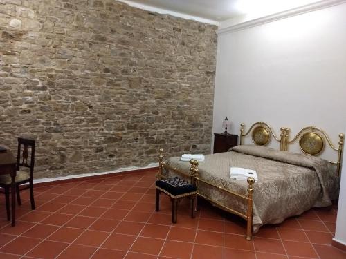 una camera con letto e muro di mattoni di Castel di Pietra a Pietra Montecorvino