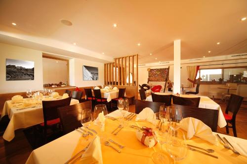 a restaurant with tables and chairs with white tablecloths at Gut Hanneshof in Erpfendorf