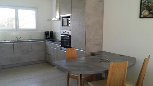uma cozinha com uma mesa e uma mesa e cadeiras em Gite du patureau em Belleray