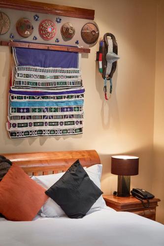 a bedroom with a bed with blankets hanging on the wall at AmmaZulu African Palace in Kloof