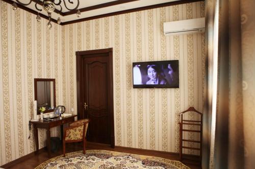 un soggiorno con TV a parete di Hotel Naxshab a Karshi