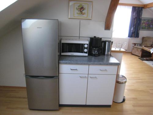 a kitchen with a refrigerator and a microwave at Landhaus-Stockinger in Büchlberg