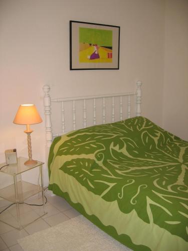 - une chambre avec un lit doté d'une couverture verte et d'une lampe dans l'établissement Luxury apartment facing the Mediterranean, à Sète