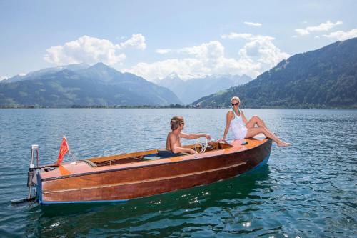 two people sitting on a boat on a lake at Aparthotel Zell am See (Contactless Check-In) in Zell am See