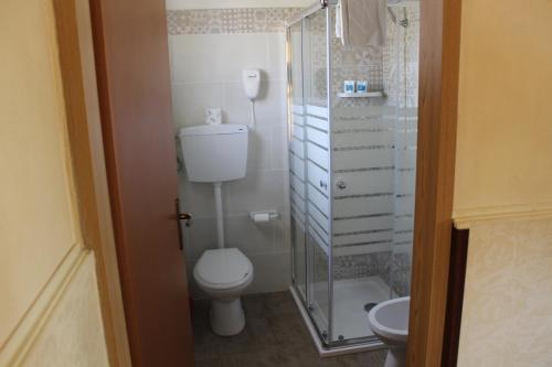 ein Bad mit einem WC und einer Glasdusche in der Unterkunft Agriturismo La Maddalena in Acate