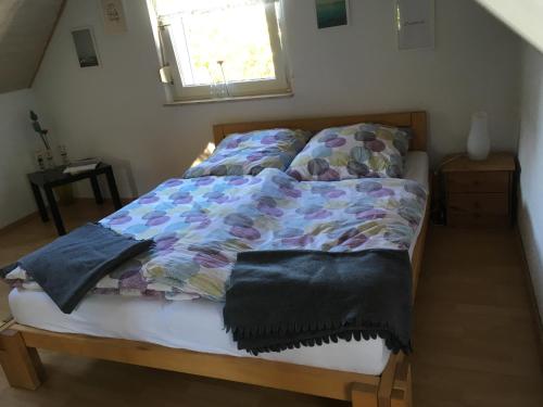 1 dormitorio con cama con edredón y ventana en Apartment Düsseldorf-Süd, en Düsseldorf