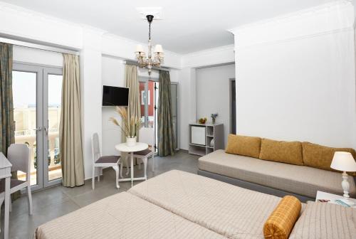 a living room with a bed and a couch at Blue Sea Hotel in Kamari