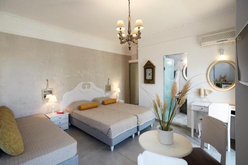 a bedroom with two beds and a table and a mirror at Blue Sea Hotel in Kamari
