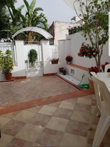 a courtyard with potted plants and a white wall at Mondello Home "46 passi" in Palermo