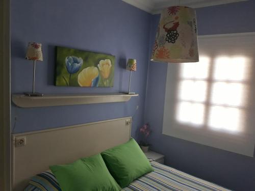 une chambre avec un lit avec des oreillers verts et une fenêtre dans l'établissement Casa Costa Amanecer, à Punta de Mujeres