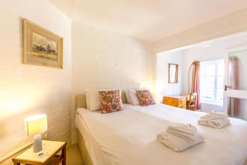 a bedroom with a bed with two towels on it at 5 Coastguard Cottages in Aldeburgh