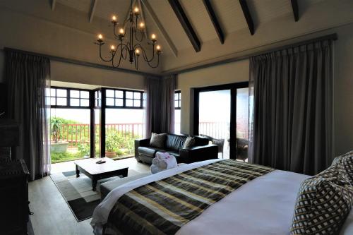 
a hotel room with a large bed and a large window at Dolphin Dunes Guesthouse in Wilderness
