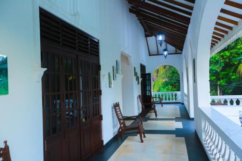 a hallway of a house with two doors and chairs at SRI LANKAN VILLA in Galle